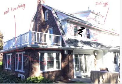 Greige and white lap siding paired with brick on a gambrel home in Belmont, MA