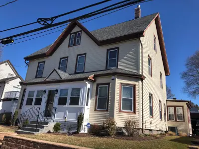Cream CertainTeed vinyl siding with brown trim on a home in Boston, MA - photo 5