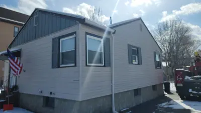 Navy blue vinyl lap siding installation in progress on a Boston, MA home - photo 13