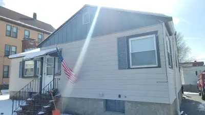Navy blue vinyl lap siding installation in progress on a Boston, MA home - photo 14