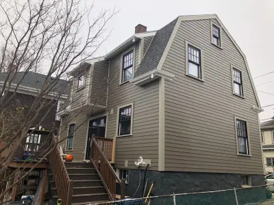 Warm greige James Hardie lap siding with cream trim on a home in Boston, MA - photo 14