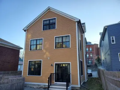 Golden ochre wood clapboard siding with black windows in Boston, MA - photo 4
