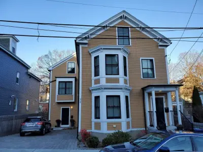 Golden ochre wood clapboard siding with black windows in Boston, MA - photo 5