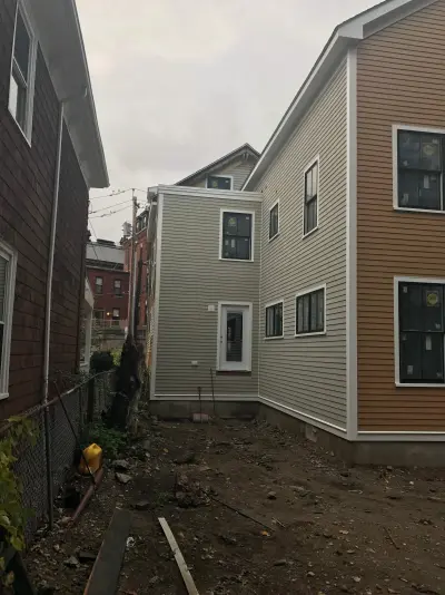 Golden ochre wood clapboard siding with black windows in Boston, MA - photo 9