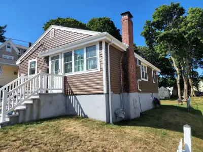 Brown vinyl lap siding with cream trim on a home in Boston, MA - photo 5
