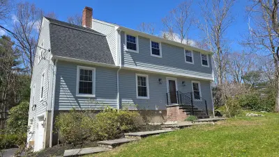 Light gray fiber cement lap siding with white trim on a gambrel home in Dover, MA - photo 6