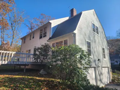 Light gray fiber cement lap siding with white trim on a gambrel home in Dover, MA - photo 22