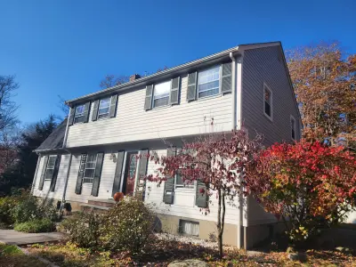Light gray fiber cement lap siding with white trim on a gambrel home in Dover, MA - photo 25