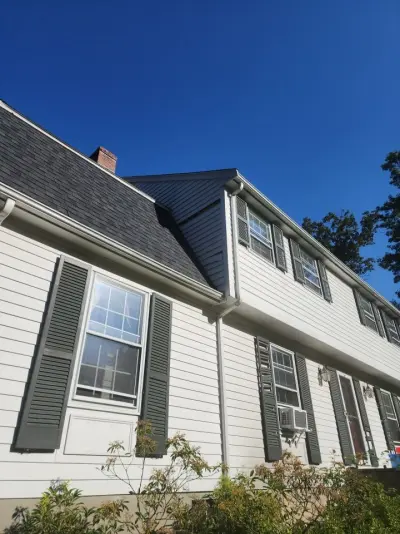 Light gray fiber cement lap siding with white trim on a gambrel home in Dover, MA - photo 31