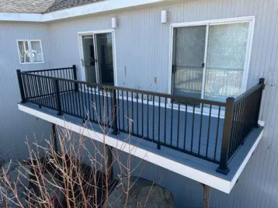 Gray composite deck with black aluminum railings on a gray home in Gloucester, MA - photo 6