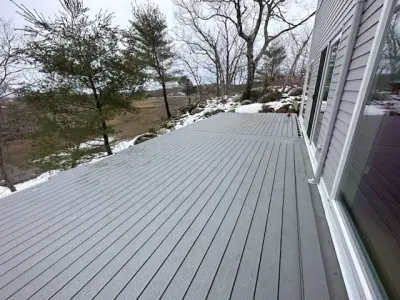 Gray composite deck with black aluminum railings on a gray home in Gloucester, MA - photo 15