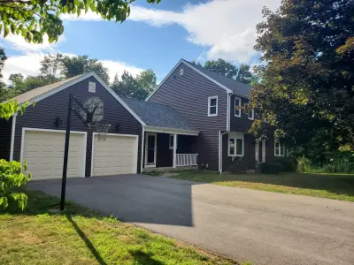 Deep brown CertainTeed vinyl siding with cream trim on a home in Marlboro, MA