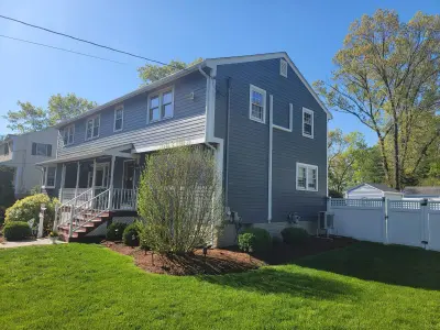 Side wall in blue-gray lap siding running two stories to a shed dormer