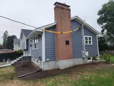 Blue-gray composite lap siding with white trim on a split-level home in Needham, MA - photo 6