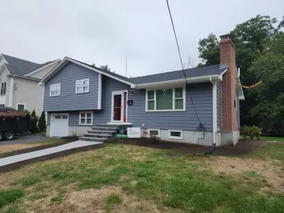 Blue-gray composite lap siding with white trim on a split-level home in Needham, MA - photo 7