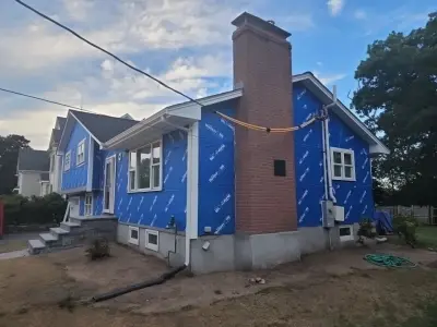 Blue-gray composite lap siding with white trim on a split-level home in Needham, MA - photo 9