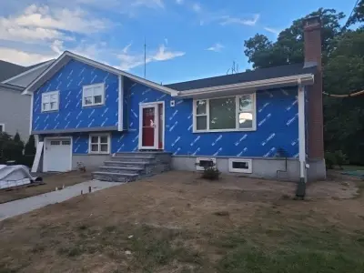 Blue-gray composite lap siding with white trim on a split-level home in Needham, MA - photo 10