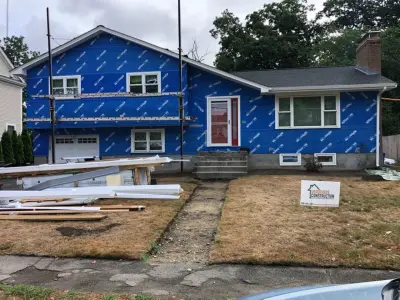 Blue-gray composite lap siding with white trim on a split-level home in Needham, MA - photo 11