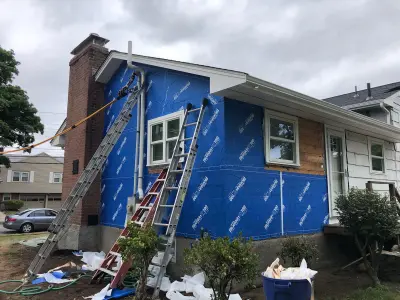 Blue-gray composite lap siding with white trim on a split-level home in Needham, MA - photo 15