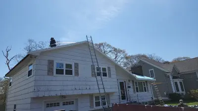 Blue-gray composite lap siding with white trim on a split-level home in Needham, MA - photo 17
