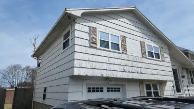 Blue-gray composite lap siding with white trim on a split-level home in Needham, MA - photo 18