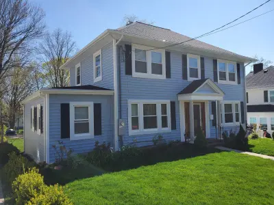 Light blue vinyl siding with white trim and black shutters on a home in Norwood, MA - photo 5