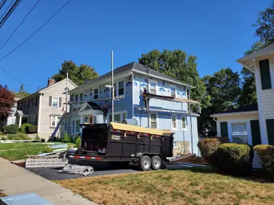 Light blue vinyl siding with white trim and black shutters on a home in Norwood, MA - photo 14