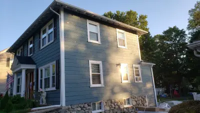 Light blue vinyl siding with white trim and black shutters on a home in Norwood, MA - photo 19