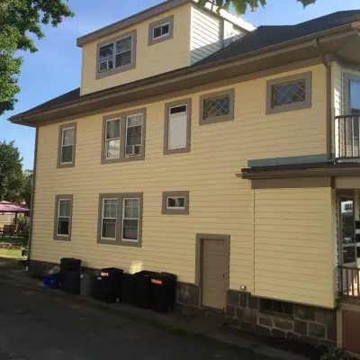 Dark brown shingle-style siding with cream trim on a multi-family home in Quincy, MA - photo 7