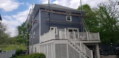 Gray-blue vinyl lap siding installation over housewrap in Quincy, MA - photo 23