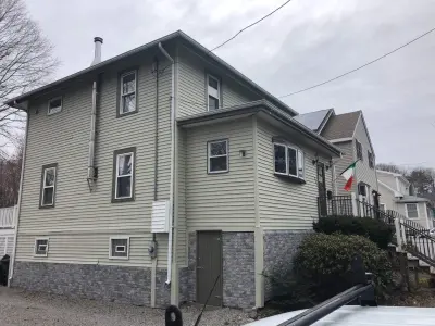 Gray-blue vinyl lap siding installation over housewrap in Quincy, MA - photo 24