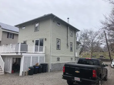 Gray-blue vinyl lap siding installation over housewrap in Quincy, MA - photo 27