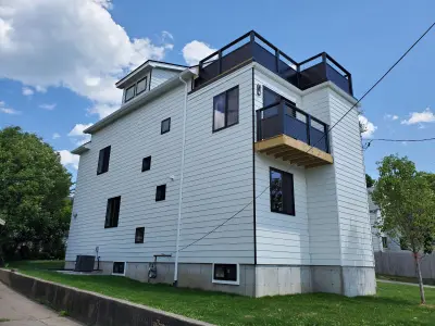 White James Hardie lap siding with black windows on a modern home in Quincy, MA - photo 4