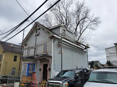 Medium blue wood clapboard siding on a restored three-decker in Somerville, MA - photo 25
