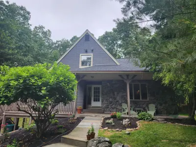 Dark blue-gray vinyl siding with beige trim on a gabled home in Upton, MA