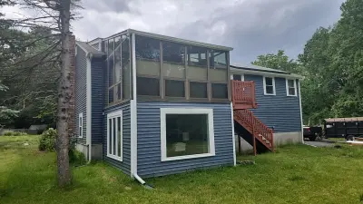 Rear elevation with new windows, screened porch above and painted wood stair down