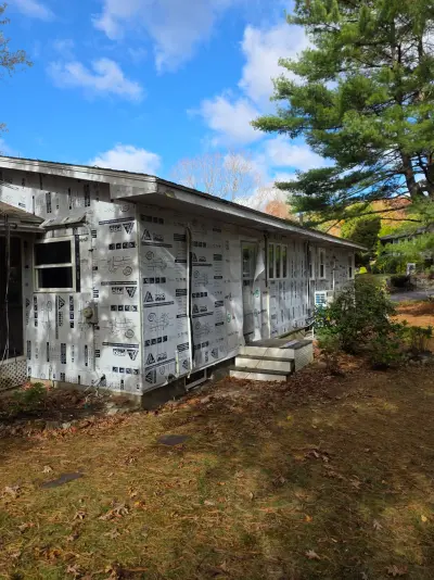 Rigid foam insulation board and new windows installed before siding on a ranch home